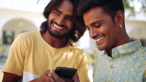 Indian-friends-outdoor-in-nature-park-using-smart-phone-mobile