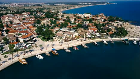 Aerial-travel-video-view-of-old-city-with-yacht-and-boats-at-marina-in-front-of-it.-Waterfront,-ocean-river-marina-port-dock,-boats-ships