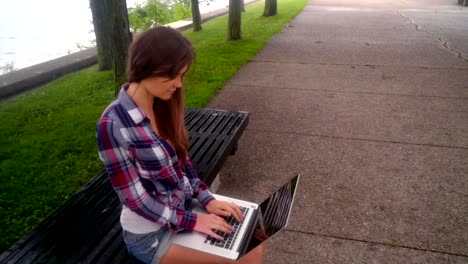 Young-woman-typing-laptop.-Girl-using-laptop-outside.-Woman-with-laptop-outside