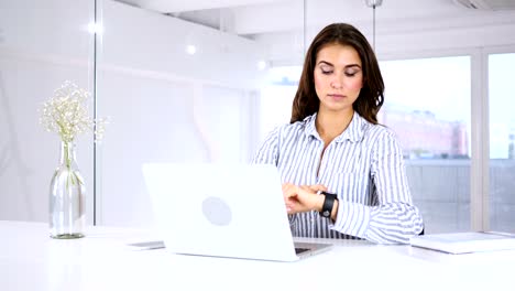 Young-Woman-Using-Smartwatch,-Sitting-in-Office