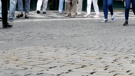 Viele-Füße-eine-Menge-von-Menschen-Flanieren-entlang-dem-Kopfsteinpflaster-der-Stadt