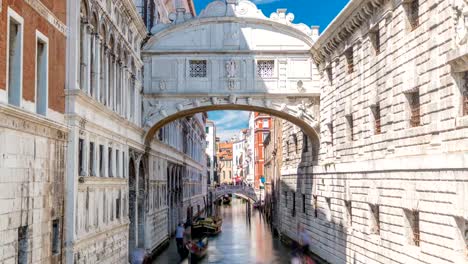 Gondolas-floating-on-canal-towards-Bridge-of-Sighs-timelapse-Ponte-dei-Sospiri-.-Venice,-Italy