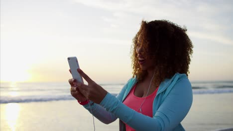 Ethnische-weiblich-im-Chat-auf-video-zu-Fuß-am-Strand