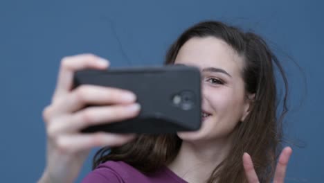 Cute-girl-taking-selfies-with-her-smartphone