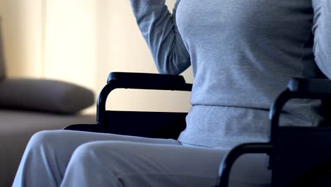 Woman-with-disabilities-exercising-with-dumbbells,-sitting-in-wheelchair