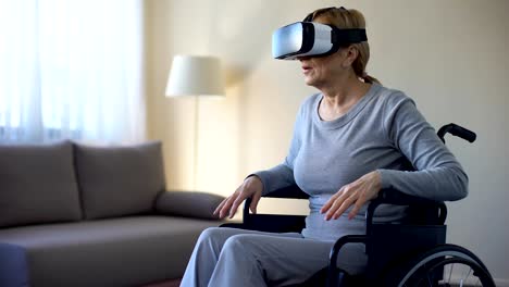 Aged-female-sitting-in-wheelchair-and-wearing-virtual-reality-headset,-game