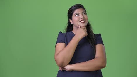 Young-overweight-beautiful-Indian-businesswoman-against-green-background