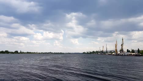 Der-Binnenhafen-akzeptiert-und-Schiffe-die-Ladung-über-das-Wasser.-Geheimnisvolle-Wolken-fliegen-sehr-niedrig-über-den-Fluss.