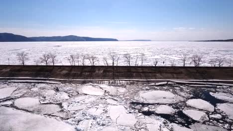 eine-Drohne-fliegen-über-einen-gefrorenen-Fluss,-Wasser-und-Eis-auf-einem-gefrorenen-Fluss