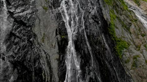 Seguimiento-y-top-tiro-de-aire-de-una-corriente-de-agua-que-salpica-la-cascada-en-un-muro-de-roca-en-las-montañas-del-Cáucaso.-Todo-el-chorro-de-la-cascada