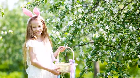 Entzückende-kleine-Mädchen-in-blühender-Apfelgarten-an-schönen-Frühlingstag