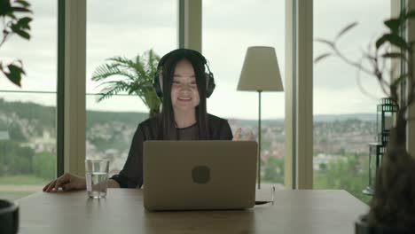 Young-woman-sitting-at-home-working-with-computer-and-chair-dancing