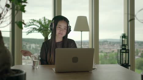 Young-woman-sitting-at-home-working-with-computer-and-chair-dancing