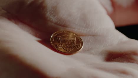 A-hand-opens-revealing-an-extreme-close-up-of-an-American-penny.--At-the-end,-the-hand-then-closes-around-it-for-safe-keeping.