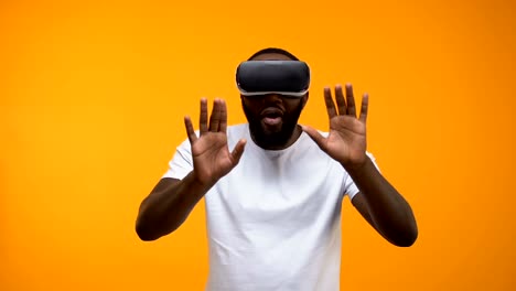 Amazed-Afro-American-man-in-VR-headset-exploring-modern-technologies,-future