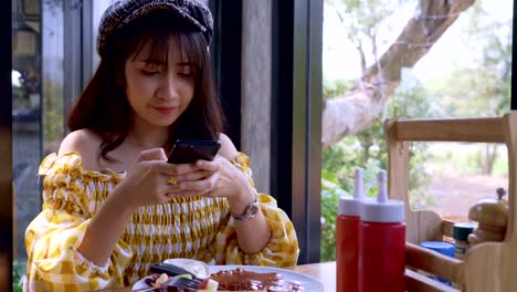 Asian-young-woman-taking-a-photo-of-breakfast-with-smartphone-social-media