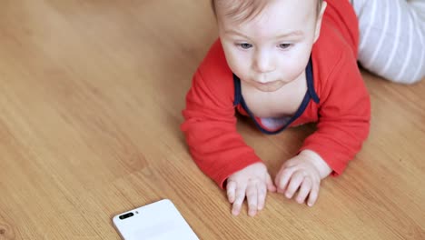 Baby-Boy-spielt-mit-einem-Smartphone