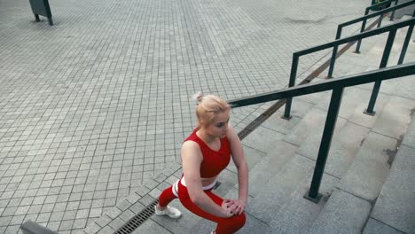 Plus-size-mixed-race-blonde-smiling-woman-wearing-red-sportswear-warm-up-before-run