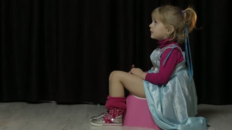 Little-girl-sitting-on-the-potty-and-watching-TV