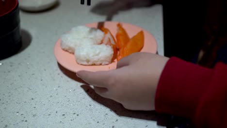 Little-girl-eats-sushi-at-a-Japanese-restaurant.-The-little-girl-is-wearing-a-hearing-aid.