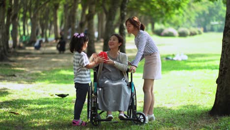 La-hija-más-joven-sorprende-a-la-madre-con-caja-de-regalo-en-el-Parque