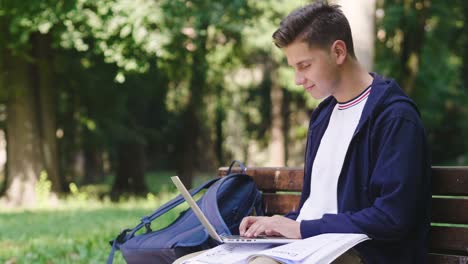 Un-estudiante-sentado-en-un-banco-utiliza-el-teléfono-para-enviar-mensajes,-y-navegar-en-las-redes-sociales-y-mantenerse-en-contacto-con-sus-amigos.