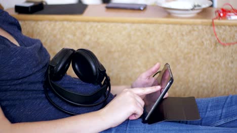 Young-Woman-Lying-on-Bed-and-using-Tablet-at-Home