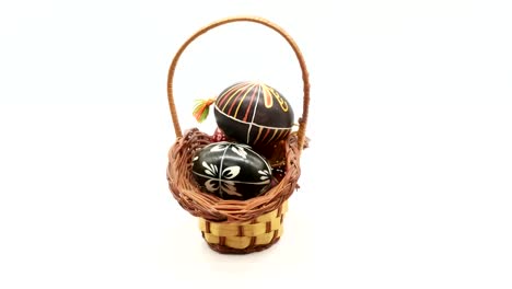 decorative-basket-with-painted-Easter-eggs-on-white-background