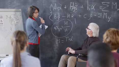 Lehrer-hört-Student-auf-Student-stehen-an-Blackboard