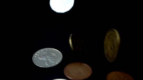 Coins-fall-on-a-black-background.-Slow-motion.