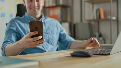 Businessman-Sitting-at-His-Desk-Works-on-Desktop-Computer-in-the-Stylish-Office,-Picks-up-and-Starts-Using-Smartphone,-Uses-Social-Media-App,-Emailing-Business-Partners,-Messaging.-Focus-On-Hands-and-Phone