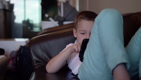 Kid-with-digital-tablet-relaxing-in-airport-lounge