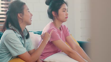 Young-Asian-Lesbian-couple-angry,-conflict,-sad-flight-annoyed-on-sofa-in-living-room-at-home.