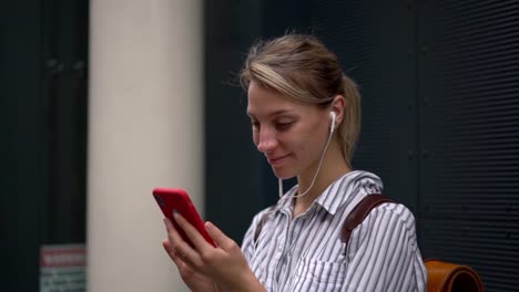 Efecto-de-cámara-lenta-de-la-mujer-feliz-escuchando-música-a-través-de-la-aplicación-en-el-teléfono-mientras-lee-el-texto-del-contenido-en-la-página-web