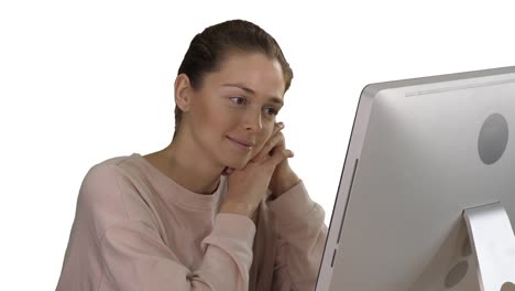 Blonde-girl-with-pink-pullover-looking-at-monitor-of-computer-watching-video-on-white-background