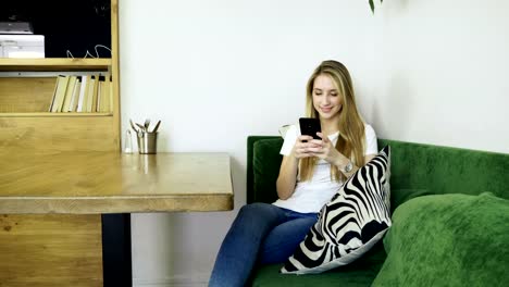 Attractive-young-happy-woman-using-mobile-phone-during-resting-in-a-cafe.-4K