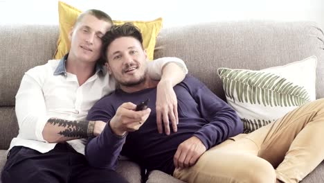 Pareja-gay-relajándose-en-el-sofá.-Mirando-la-televisión.