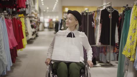 Mujer-en-silla-de-ruedas-comprando-en-la-tienda-de-ropa