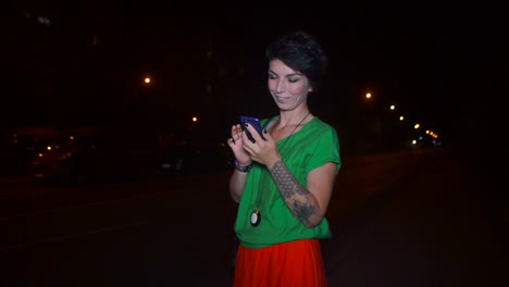 smartphone-in-hands-of-a-girl-who-is-standing-near-the-road-waiting-for-a-taxi