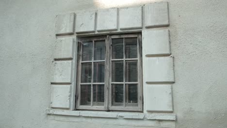 vieja-ventana-de-madera,-en-un-edificio-gris-en-mal-estado,-alrededor-de-telarañas-y-la-suciedad