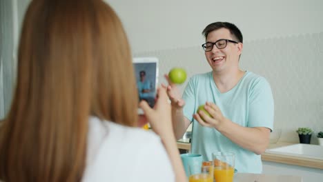 Zeitlupe-des-Mannes-jonglieren-Äpfel,-während-Frau-fotografieren-mit-dem-Smartphone