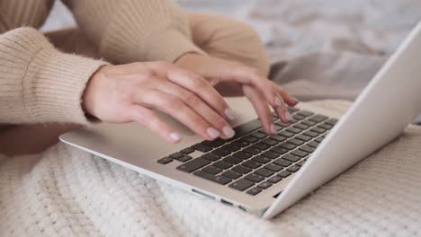 Glückliche-Frau-mit-Laptop-im-Bett