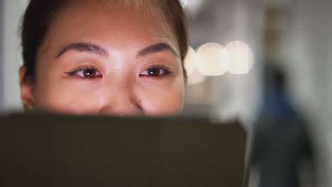 Close-Up-Abendaufnahme-von-Geschäftsfrau-steht-im-Korridor-des-modernen-Büros-mit-digitalen-Tablet