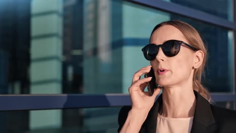 Closeup-zuversichtlich-Business-Lady-gehen-in-der-Innenstadt-sprechen-mit-Smartphone.-4k-Dragon-RED-Kamera