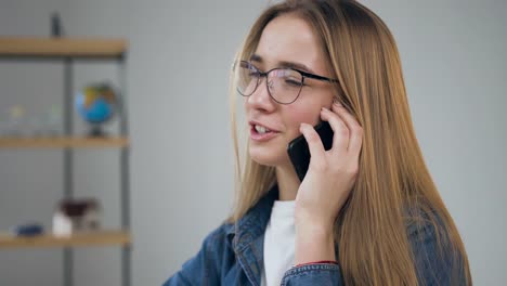 Handsome-young-woman-using-smart-phone-in-the-travel-agency