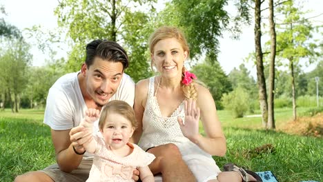 CLOSE-UP:-Happy-parents-with-beautiful-baby-girl-sitting-on-blanket-in-park