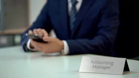 Accounting-manager-checking-email-on-smartphone,-scrolling-pages-on-screen