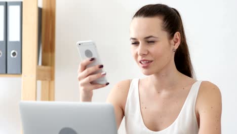 Woman-Using-Smartphone-Applications-at-Work-in-Office