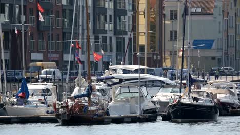 Schöne-weiße-Yachten-mit-wehenden-Fahnen-in-Gdansk-Port,-Wassertransport-geparkt