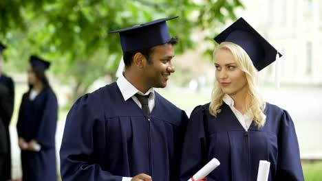 Graduate-students-looking-at-cell-phone-screen-and-having-talk,-posting-picture